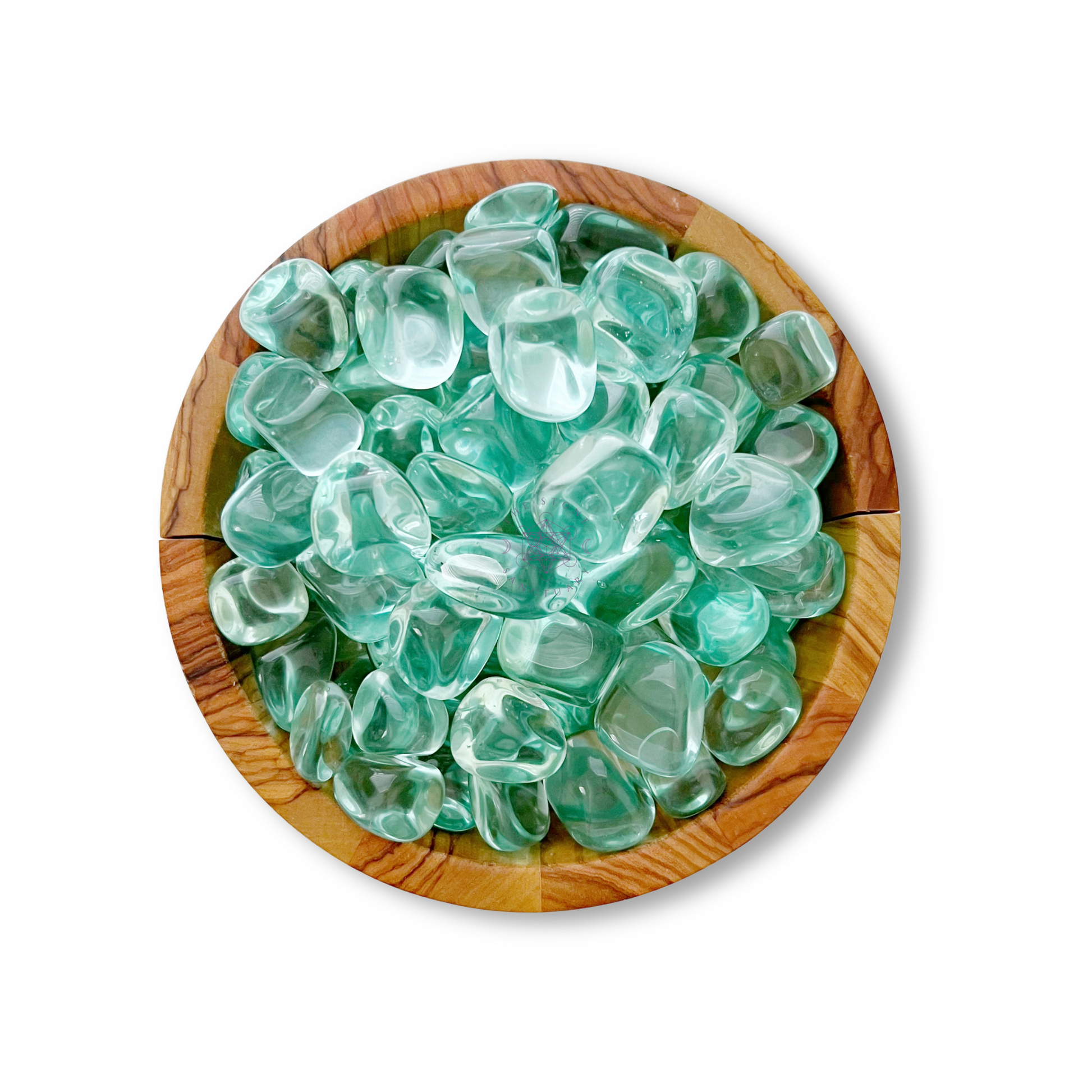 A wooden bowl filled with smooth, rounded, translucent light green Aqua Blue Obsidian Tumbled Stones, known for their healing energy, arranged closely together against a white background.