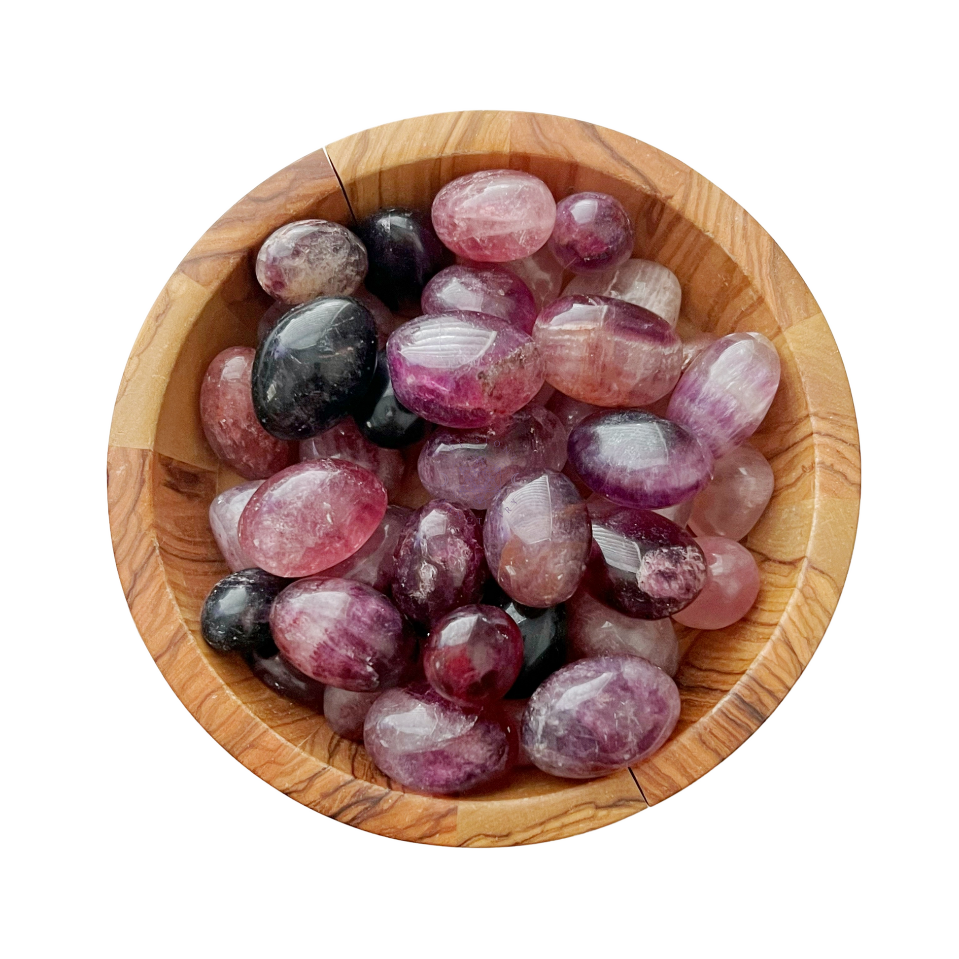 A wooden bowl contains a collection of polished, colorful Purple Fluorite Tumbled Stones. The stones are primarily hues of pink, purple, and black, with a shiny, smooth surface. The bowl's natural wood grain pattern adds contrast to the vibrant stones.