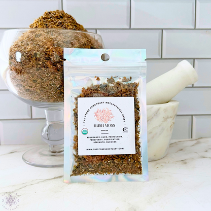 A clear, resealable bag of Irish Moss labeled with benefits sits on a white surface in front of a bowl filled with more Irish Moss. A white mortar and pestle are placed beside the bag, against a white tiled background. Perfect for spiritual rituals and holistic practices.