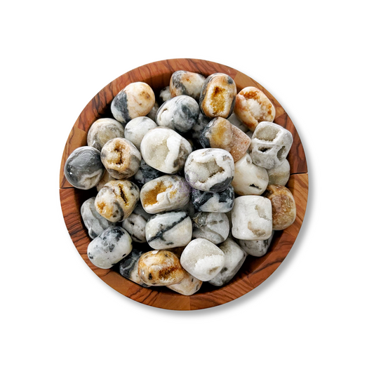 A brown wooden bowl filled with polished stones in various shades of white, gray, and brown is pictured against a white background. The stones have a smooth, rounded appearance with intricate patterns and marbling, including a striking Dendritic Agate Tumbled Stones that resembles a protective amulet.