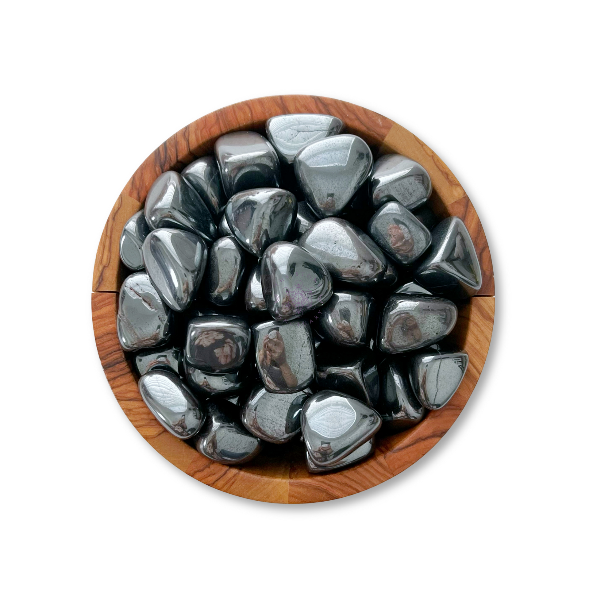 A wooden bowl filled with shiny, polished Hematite Tumbled Stones exudes grounding properties. The metallic gray stones have smooth, rounded surfaces and radiate protective energies. Set against a plain white background, this serene arrangement is both captivating and calming.