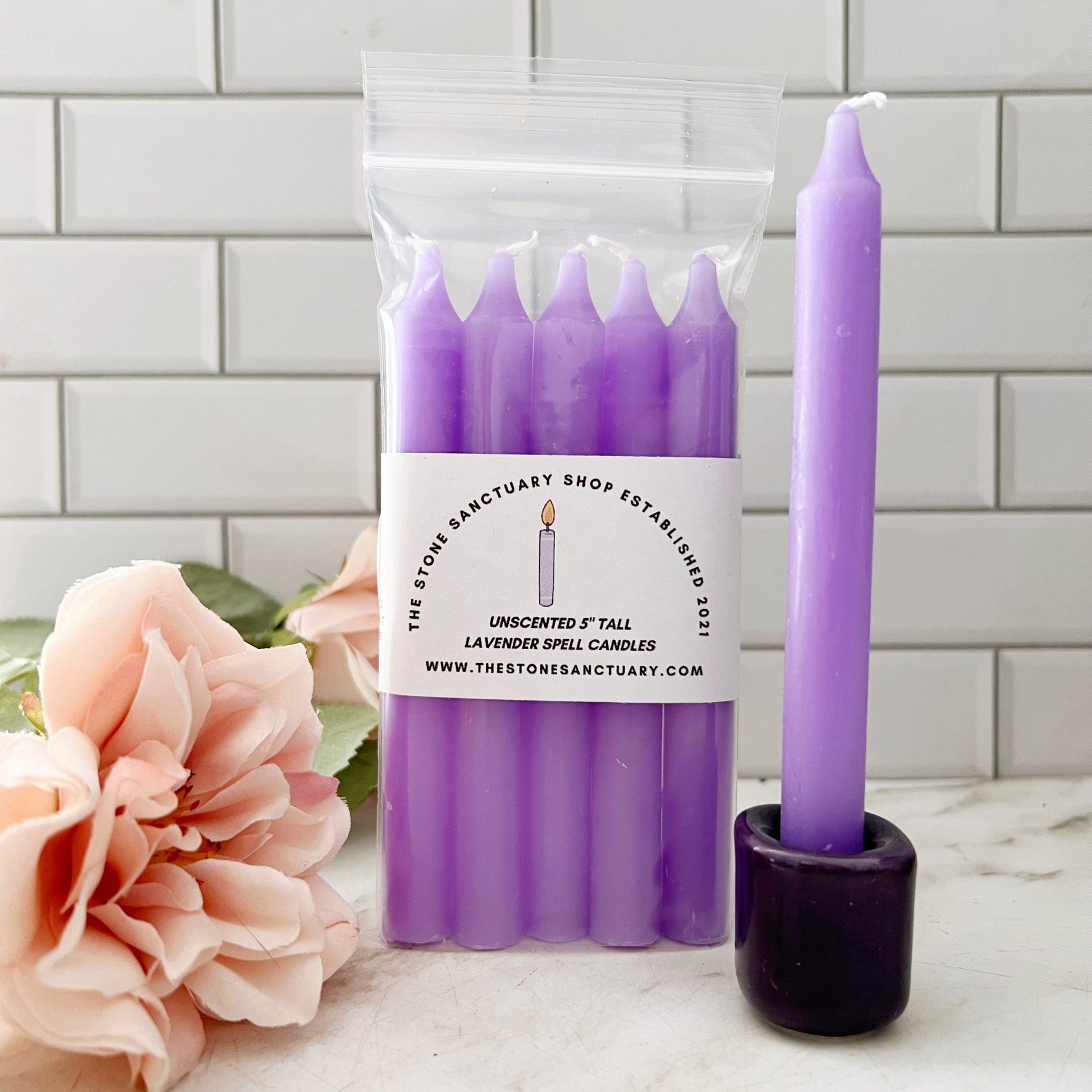 A bundle of five 5" Lavender Chime Candles, neatly aligned and tied together with a black string, rests on a white wooden background. The chime candles boast a smooth, slightly matte finish perfect for chakra balancing rituals.