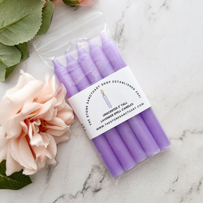 A bundle of five 5" Lavender Chime Candles, neatly aligned and tied together with a black string, rests on a white wooden background. The chime candles boast a smooth, slightly matte finish perfect for chakra balancing rituals.