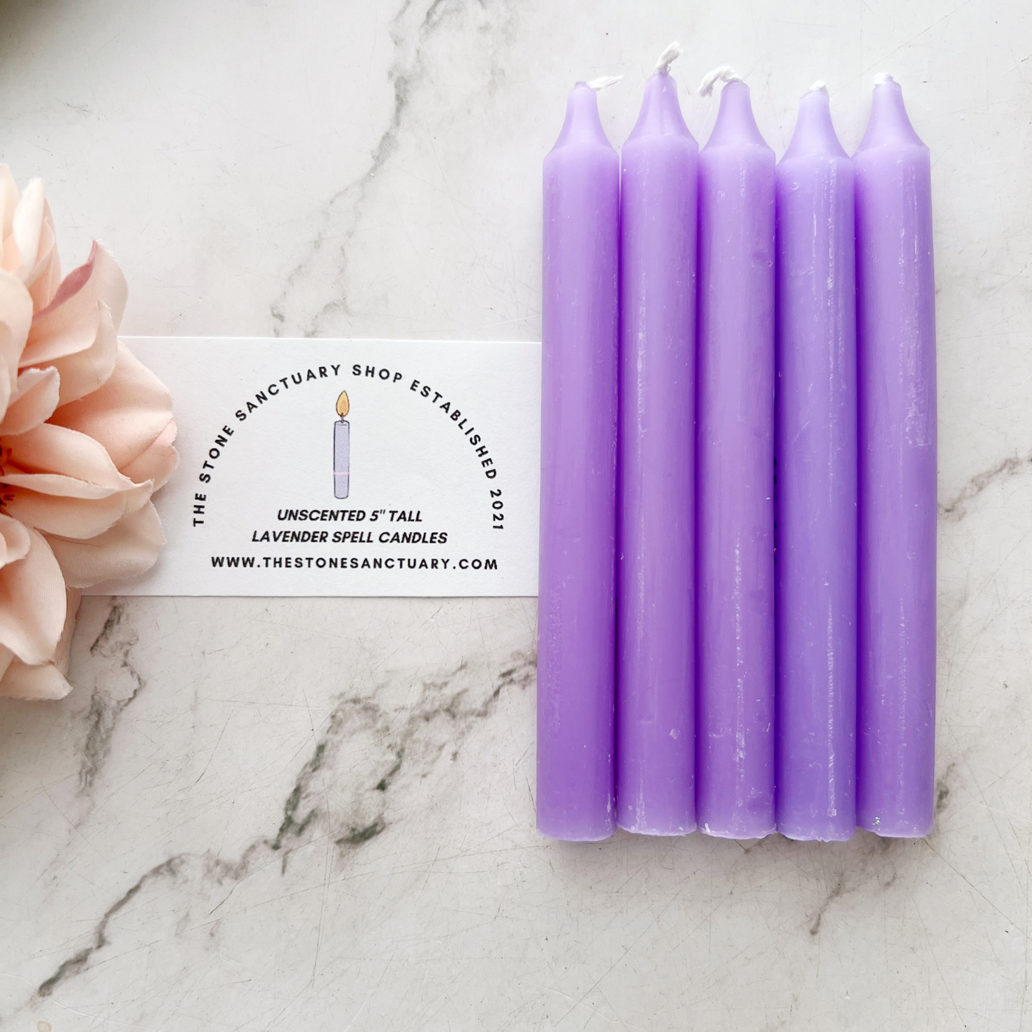 A bundle of five 5" Lavender Chime Candles, neatly aligned and tied together with a black string, rests on a white wooden background. The chime candles boast a smooth, slightly matte finish perfect for chakra balancing rituals.