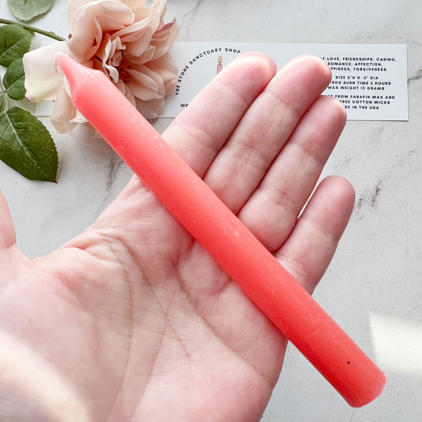 A bundle of four 5" Pink Chime Candles, tied together with a black string, placed on a white wooden surface. These ritual candles are evenly aligned, showing their pointed tips clearly against the light background.