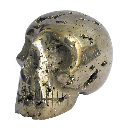 A shiny, metallic 2" Pyrite Skull, resembling a human skull, is shown under bright light. The surface is pitted and rough with numerous small holes and imperfections. This finely carved pyrite piece may also serve as one of your unique metaphysical tools.