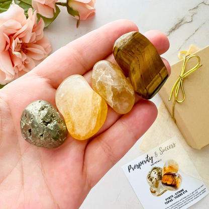 An image titled "Prosperity & Success Crystal Kit" shows four stones: pyrite, citrine, topaz, and tiger's eye. Text descriptions highlight their metaphysical properties: pyrite for manifestation, citrine for prosperity, topaz for creativity, and tiger's eye for courage—ideal crystals for prosperity and reiki energy work.