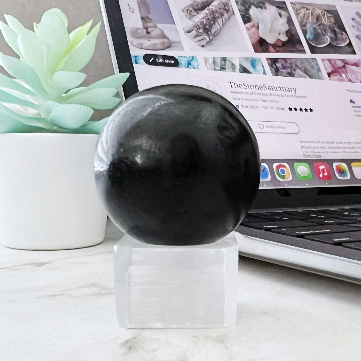 A translucent, cubic crystal with a smooth, clear surface and a shallow, concave indentation on the top center makes for an exquisite 1" Selenite Cube Sphere Holder. This crystal reflects light beautifully, showcasing its clear and glossy appearance. The sharp edges contribute to the clean and polished look, ideal for any spiritual setting.