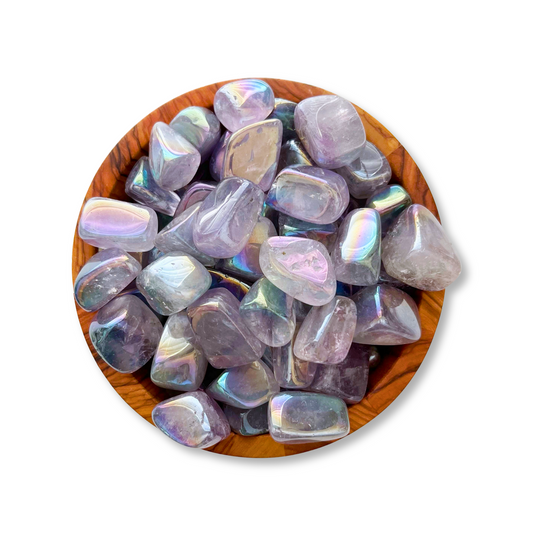 A wooden bowl filled with polished, iridescent stones. Among them, Angel Aura Amethyst Tumbled Stones shine brightly, enhancing the display with their ethereal beauty. The stones exhibit a pearly sheen with a mix of lavender and gray hues, reflecting light like a Third Eye Chakra revelation.