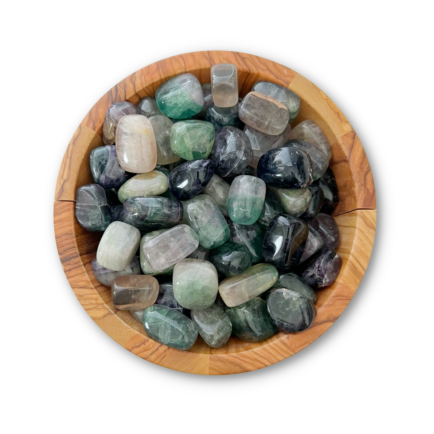 A wooden bowl filled with a collection of polished Rainbow Fluorite Tumbled Stones in various colors. The stones range in hues from green and blue to purple and clear, with smooth, rounded shapes. The bowl rests on a white background, showcasing these healing crystals beautifully.