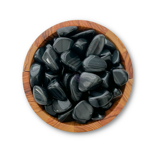 A wooden bowl filled with shiny, polished Rainbow Obsidian Tumbled Stones. The stones have smooth, glossy surfaces and subtle white or grey streaks. Known for offering protection and grounding the Root Chakra, the bowl is set against a plain white background.