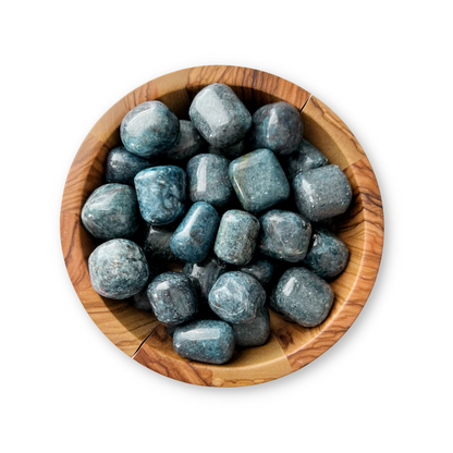 A wooden bowl filled with several smooth, rounded Blue Kyanite Tumbled Stones. The stones, reminiscent of Blue-Green Kyanite, have a polished surface with varying shades of blue and grey throughout. Perfect for chakra alignment or enhancing psychic awareness, the bowl is set against a white background.