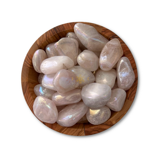 A wooden bowl filled with polished moonstones displaying a translucent, milky appearance with hints of ethereal, iridescent sheen. The stones vary slightly in size and shape but share the glowing quality of moonstone. This collection enhances heart healing and positive energy, much like Angel Aura Rose Quartz Tumbled Stones.