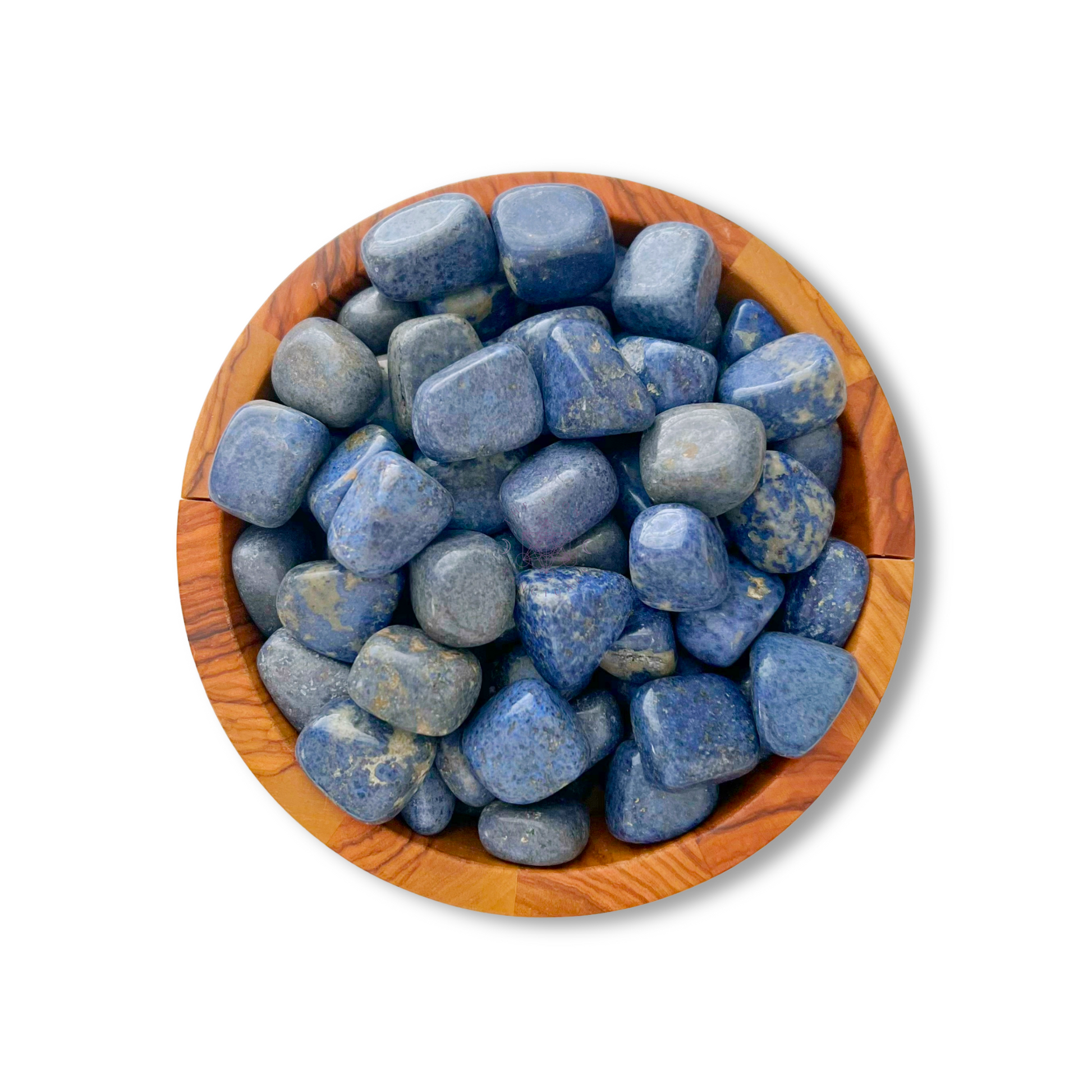 A wooden bowl filled with polished Dumortierite Tumbled Stones, each with varying shades of blue and slight flecks of white and grey. The stones are smooth and rounded, contrasting with the natural texture of the wooden bowl. Believed to enhance psychic abilities and connect to the third eye chakra, they rest against a plain white background.