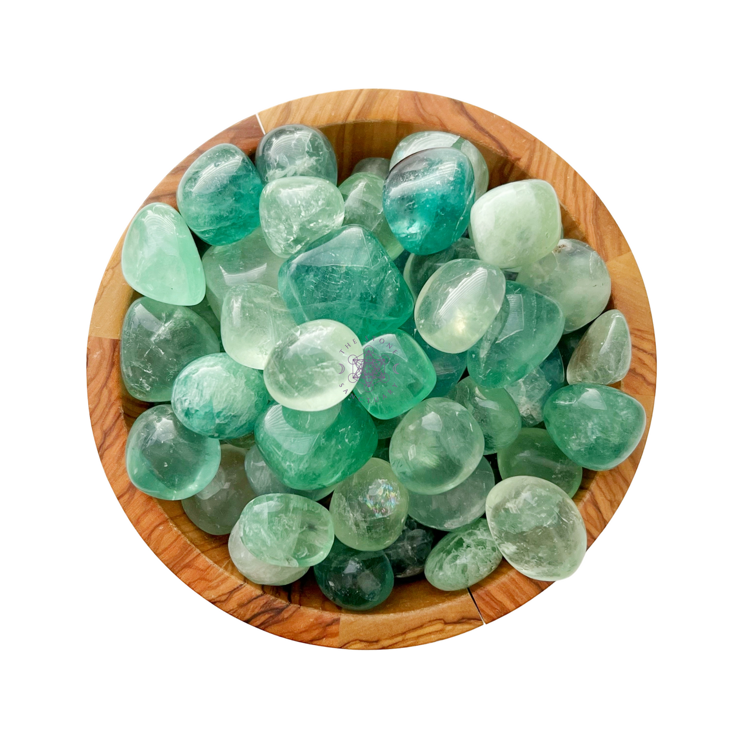 A wooden bowl is filled with various polished translucent green stones, including stunning Green Fluorite Tumbled Stones. Some have faint white or darker green swirls. The stones are smooth and glossy, reflecting light with a natural luster.