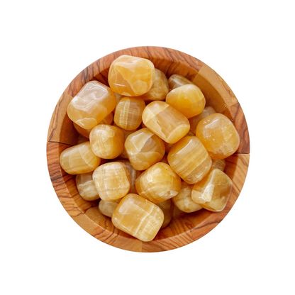 A round wooden bowl filled with polished, yellow-orange Honey Calcite Tumbled Stones. The tumbled stones have a smooth, glossy surface and vary in size and shape, giving the bowl a vibrant and reflective appearance. The white background contrasts with the bowl’s natural tones.