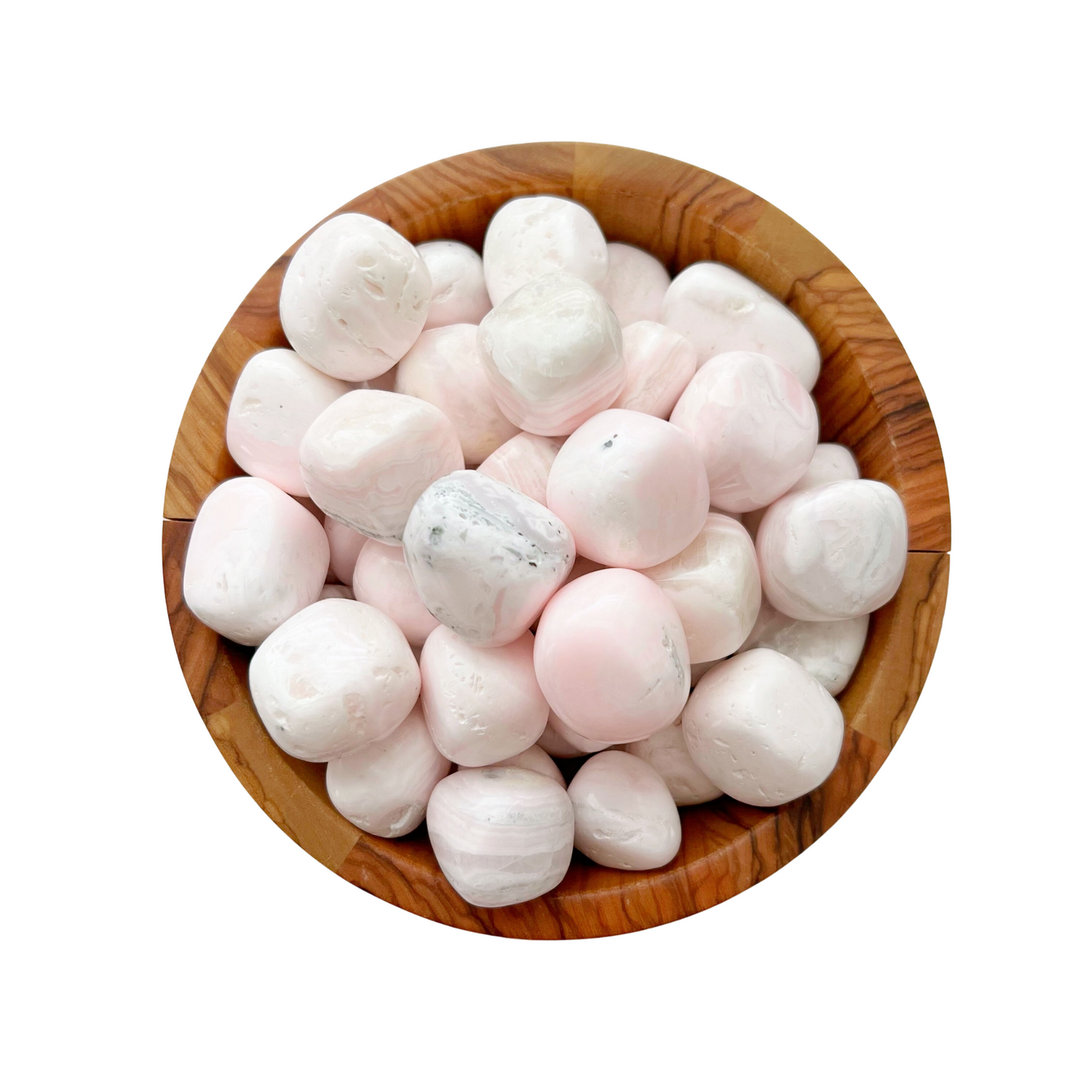 A wooden bowl filled with smooth, round Mangano Pink Calcite Tumbled Stones of pink and white hues. The stones vary slightly in size and have a polished appearance, reflecting light subtly. Known for promoting trauma healing and self-healing vibrations, they sit gracefully against a plain white background.