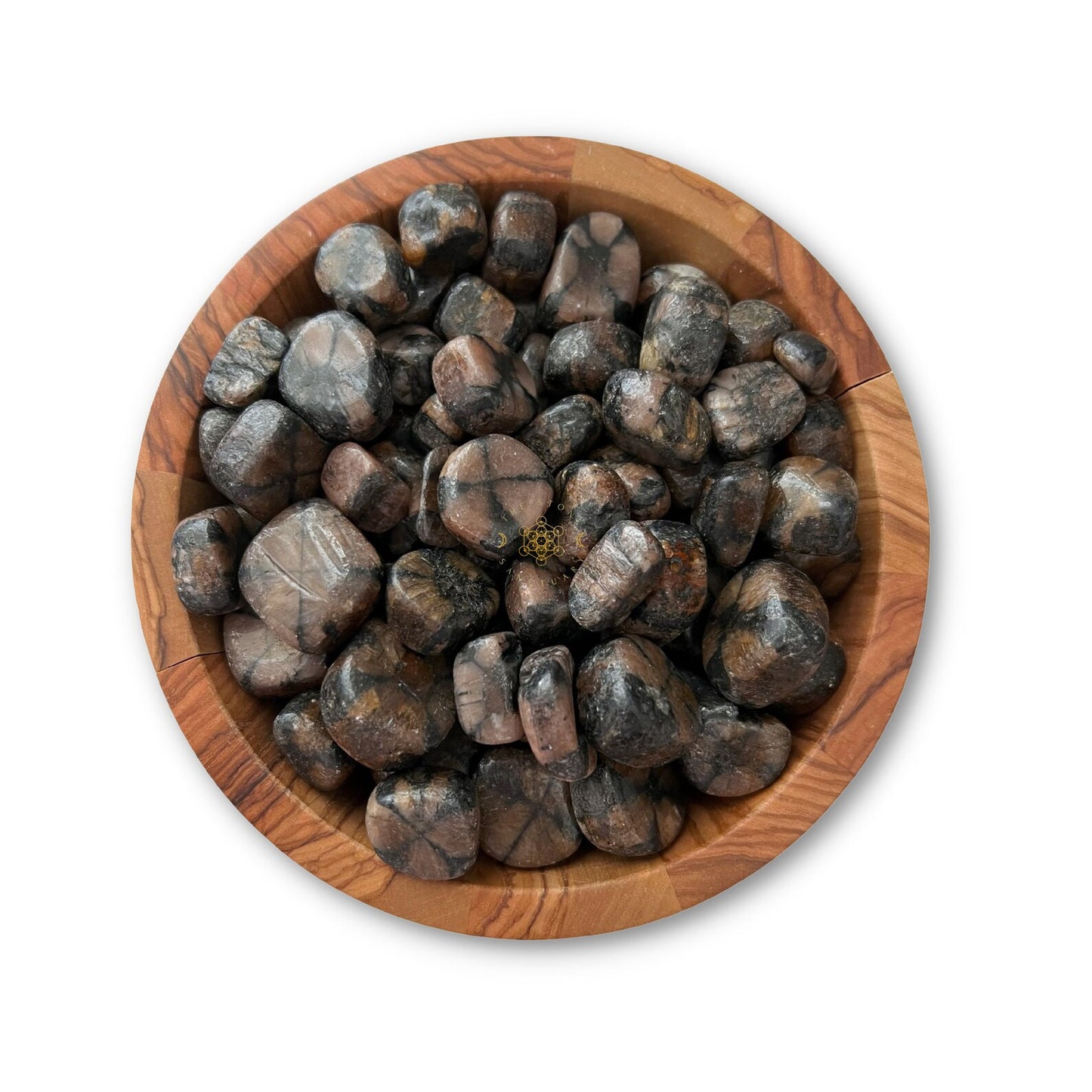 A wooden bowl filled with Chiastolite Tumbled Stones, including an ancient stone of protection, arranged neatly within the bowl. The stones vary in size and have a glossy finish, highlighting their smooth texture. The white background accentuates the bowl and its contents.