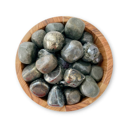 A round wooden bowl filled with smooth, shiny black and silver stones, including Covellite Tumbled Stones known for enhancing metaphysical abilities. The stones have a polished appearance in various shapes and sizes. The white background emphasizes the texture and color of the stones and the bowl.