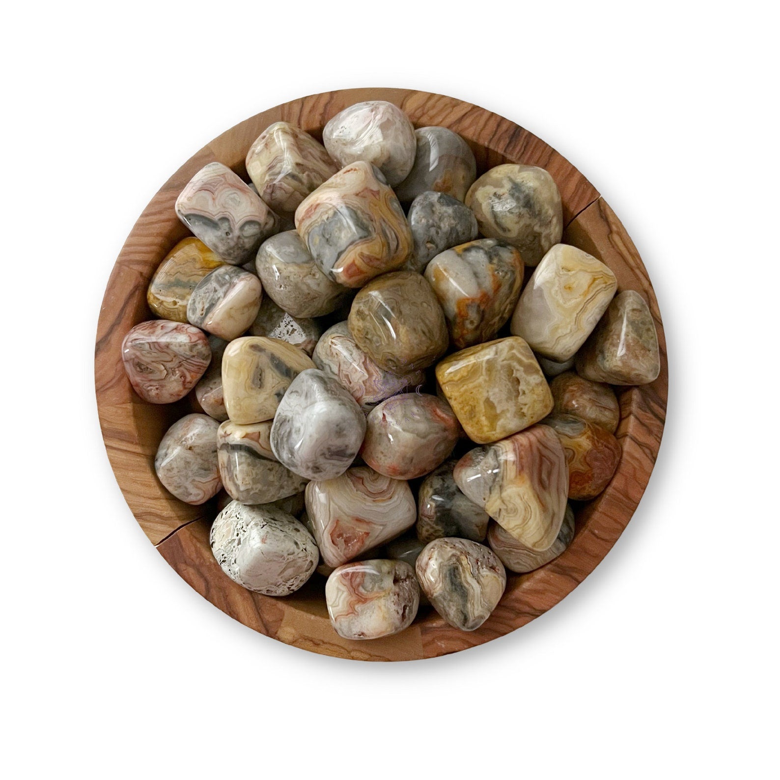 A wooden bowl filled with polished, multicolored stones. Among them are Crazy Lace Agate Tumbled Stones, exhibiting various patterns and shades of grey, brown, red, and beige that showcase their natural swirls and striations.