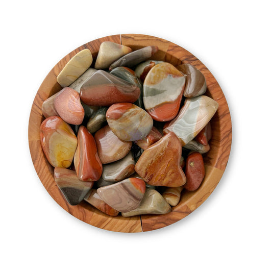 A wooden bowl filled with Polychrome Jasper Tumbled Stones, including Desert Jasper and Polychrome Jasper. The stones vary in shades of brown, red, orange, gray, and white with smooth, rounded surfaces. Perfect for crystal healing enthusiasts, the bowl rests on a white background.