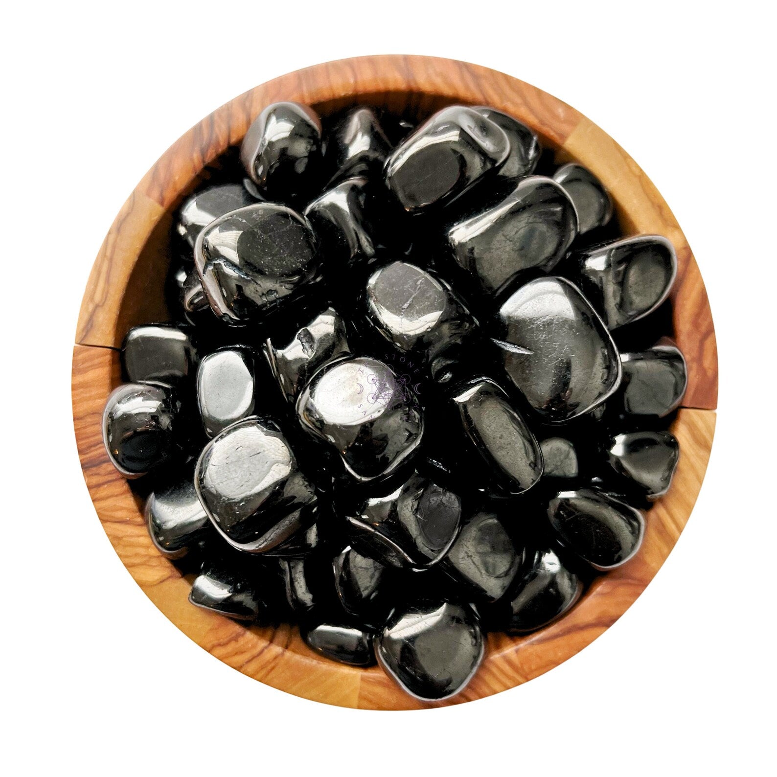 A round wooden bowl filled with smooth, shiny, Jet Tumbled Stones known for their grounding and psychic protection qualities. The stones have a reflective surface and vary slightly in size and shape.