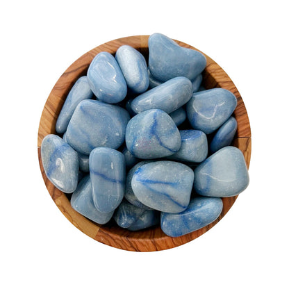 A wooden bowl filled with smooth, polished Blue Aventurine Tumbled Stones. The stones have various shades of blue with occasional white and darker blue streaks, giving them a marble-like appearance. Known as a powerful psychic activator for the Third Eye Chakra, they sit beautifully against the white background.