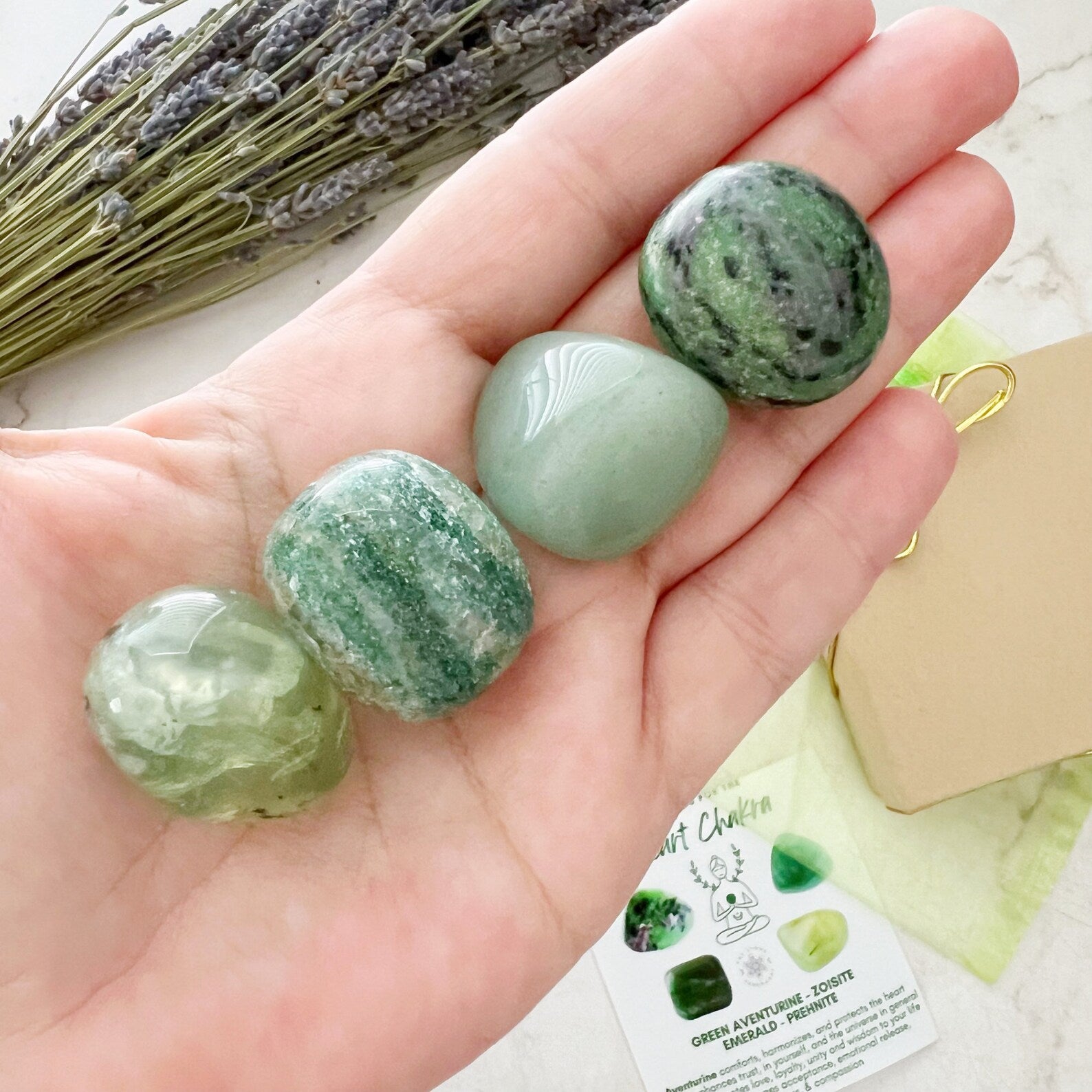 An infographic titled "Heart Chakra Crystal Kit" features four green healing crystals: Green Aventurine, Zoisite, Emerald, and Prehnite, with descriptions of their benefits. In the middle, there's an illustration of a person meditating, representing Heart Chakra alignment.