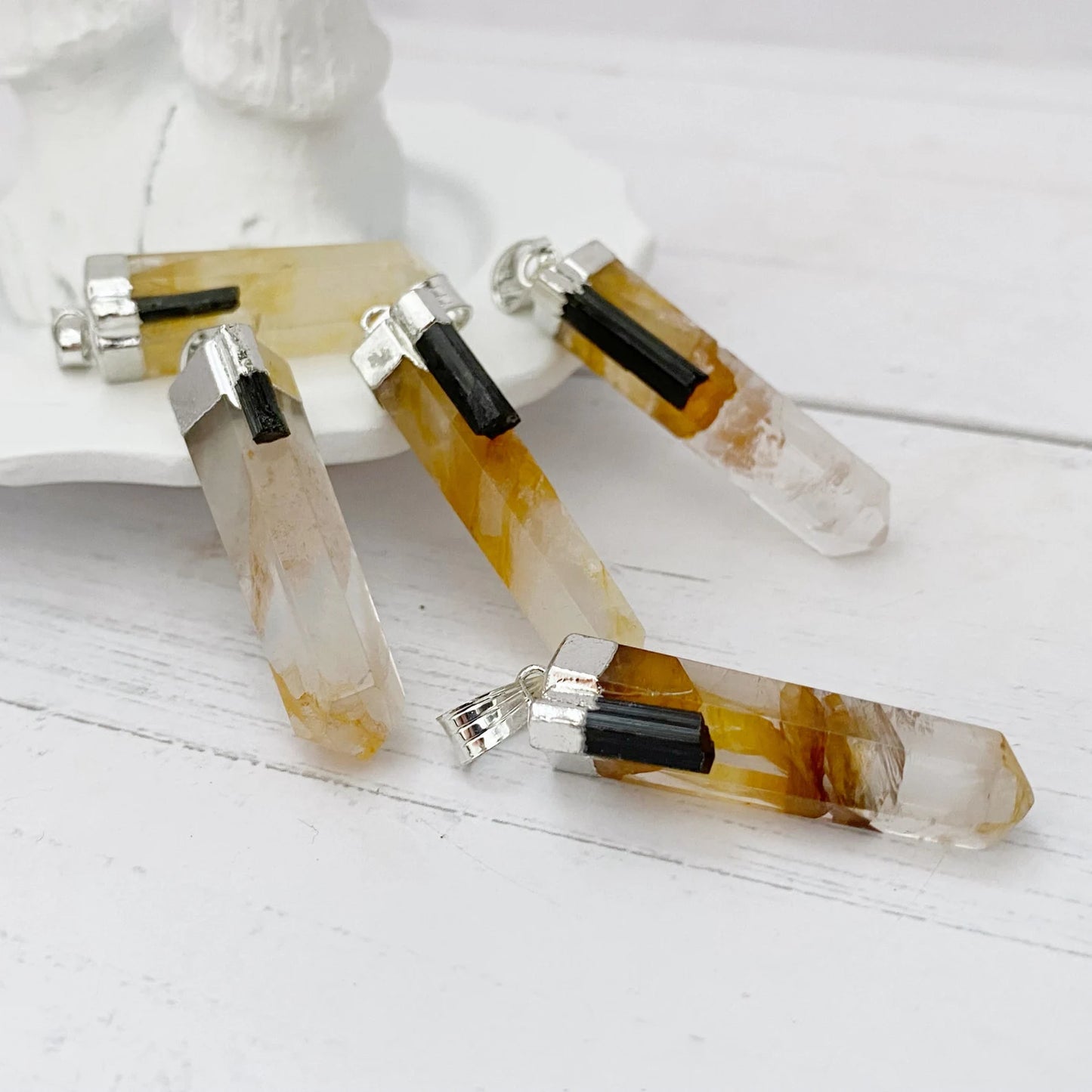 A 1" Golden Healer Quartz Point Pendant featuring a polished, faceted Golden Healer Quartz with warm yellow and brown tones. The crystal is capped with a silver plated cap and hangs from a black cord. The background is plain white.