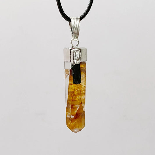 A 1" Golden Healer Quartz Point Pendant featuring a polished, faceted Golden Healer Quartz with warm yellow and brown tones. The crystal is capped with a silver plated cap and hangs from a black cord. The background is plain white.