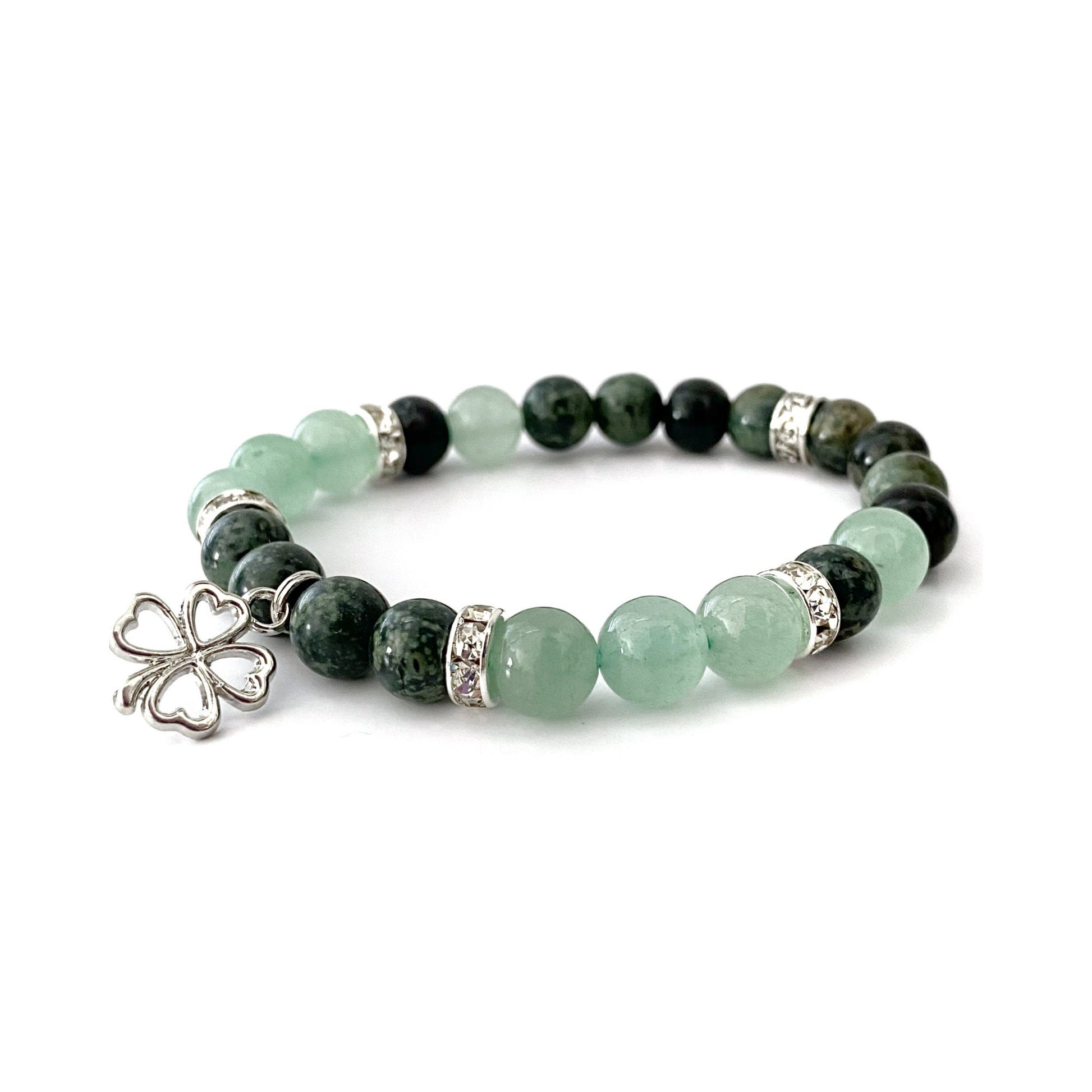 An 8mm Green Aventurine & Kambaba Jasper Beaded Bracelet featuring alternating Green Aventurine and dark green Kambaba Jasper stones, accented with silver spacers. The center of the bracelet has a silver clover charm. The bracelet is displayed on a white background.