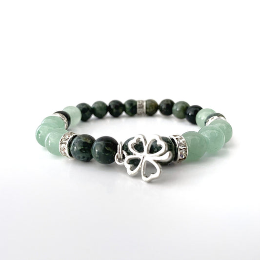 An 8mm Green Aventurine & Kambaba Jasper Beaded Bracelet featuring alternating Green Aventurine and dark green Kambaba Jasper stones, accented with silver spacers. The center of the bracelet has a silver clover charm. The bracelet is displayed on a white background.