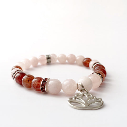 8mm Rose & Strawberry Quartz Beaded Bracelet w/Lotus Charm featuring alternating light pink and brownish-red beads with silver spacers. Accented with a lotus flower charm in silver, the design showcases Strawberry Quartz and Rose Quartz beads, displayed elegantly on a white background.