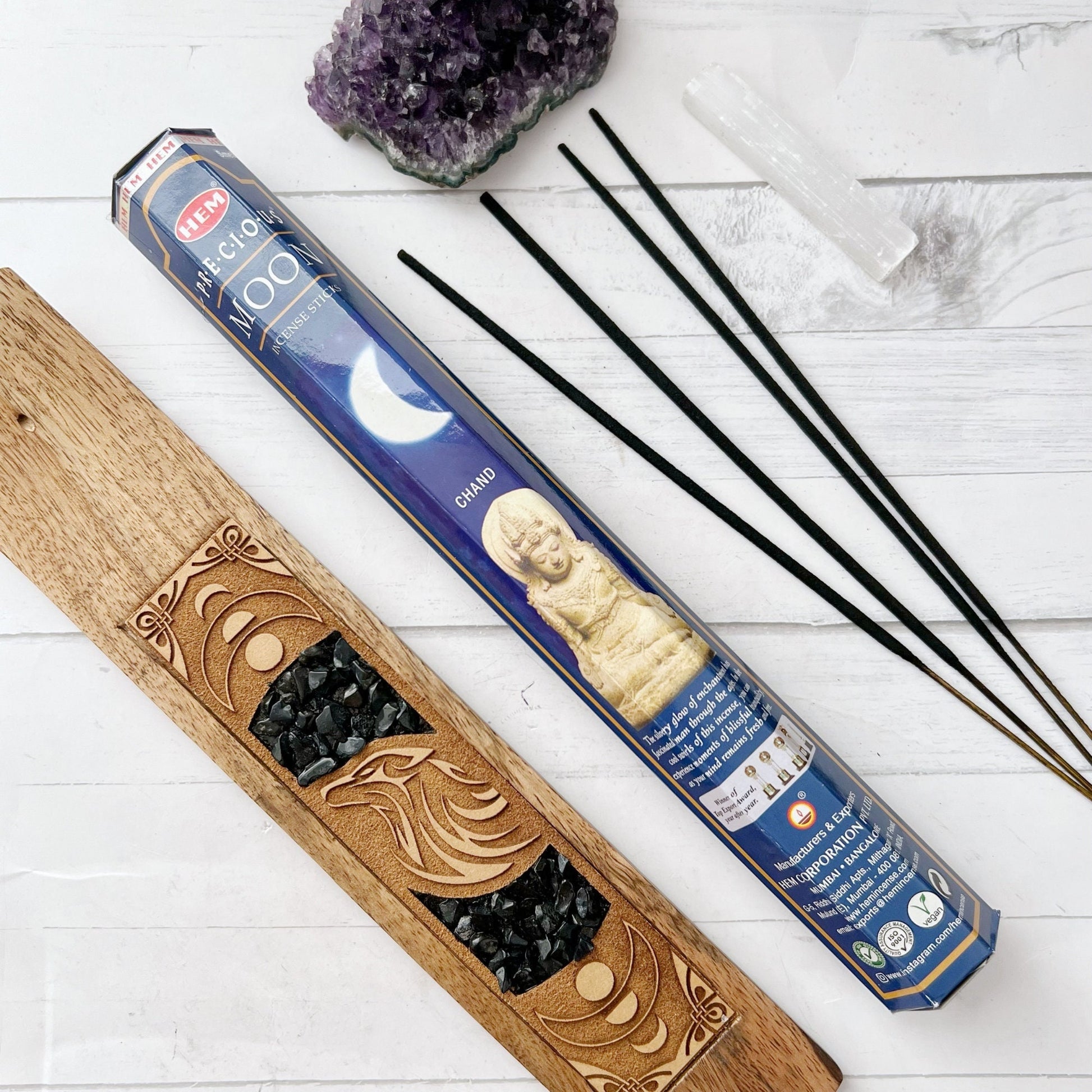 Image of The Moon Incense Sticks packaging. The box features a blue background with a crescent moon and a statue of a meditating deity on the front, evoking the tranquil ambiance ideal for meditation. The branding and product name are prominently displayed, highlighting its traditional incense heritage.