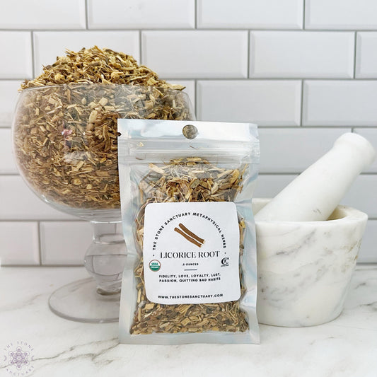 A clear glass bowl filled with dried licorice root sits next to a white mortar and pestle. In front, a labeled bag of Licorice Root from "Twin Star Sanctuary" indicates it's organic. The background features white subway tiles, alluding to its use in love spells and magical rituals.