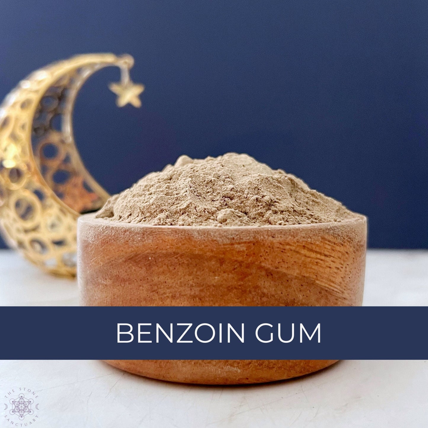 A wooden bowl filled with a light brown powder labeled "Benzoin Resin Powder" against a dark blue background. In the background, there is a crescent moon-shaped decorative item with a small star hanging from its tip, evoking the essence of spiritual practices and incense blends.